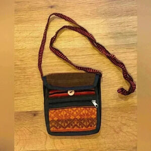Woven fabric purse with button close main section and zip front pocket